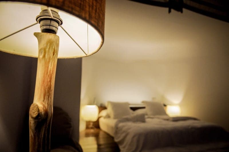 A bedside lamp casting warm light next to a bed