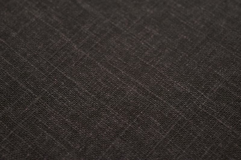 Folded linen bedding in warm, low light